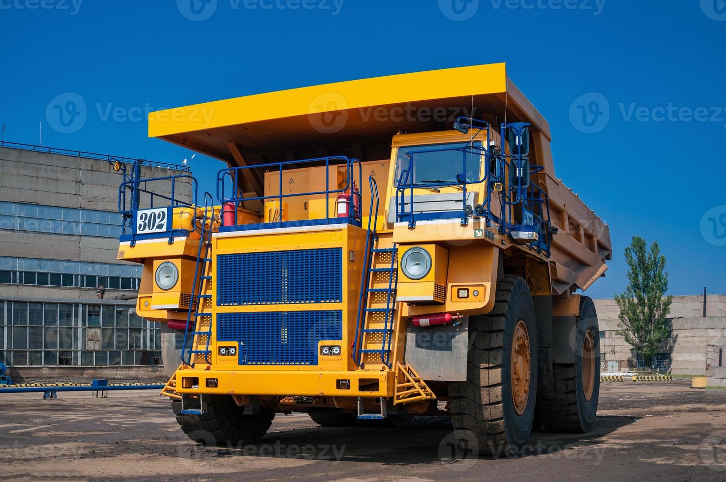 heavy yellow open cast mine dump trucks at repair station at sunny cloudless day photo