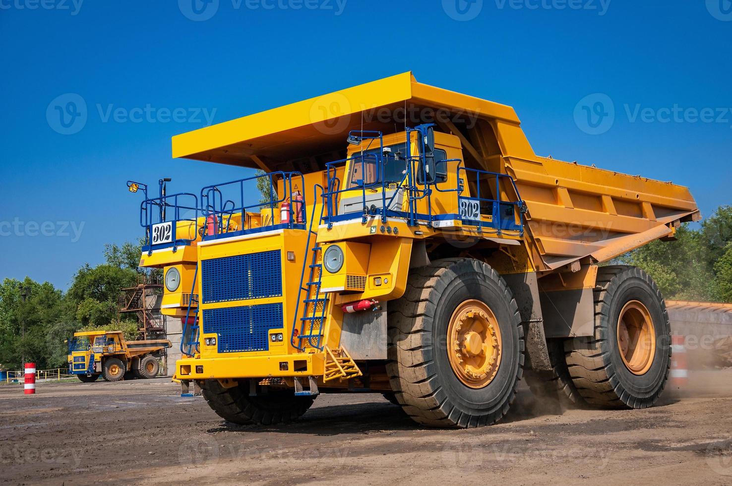 heavy yellow open cast mine dump trucks at repair station at sunny cloudless day photo