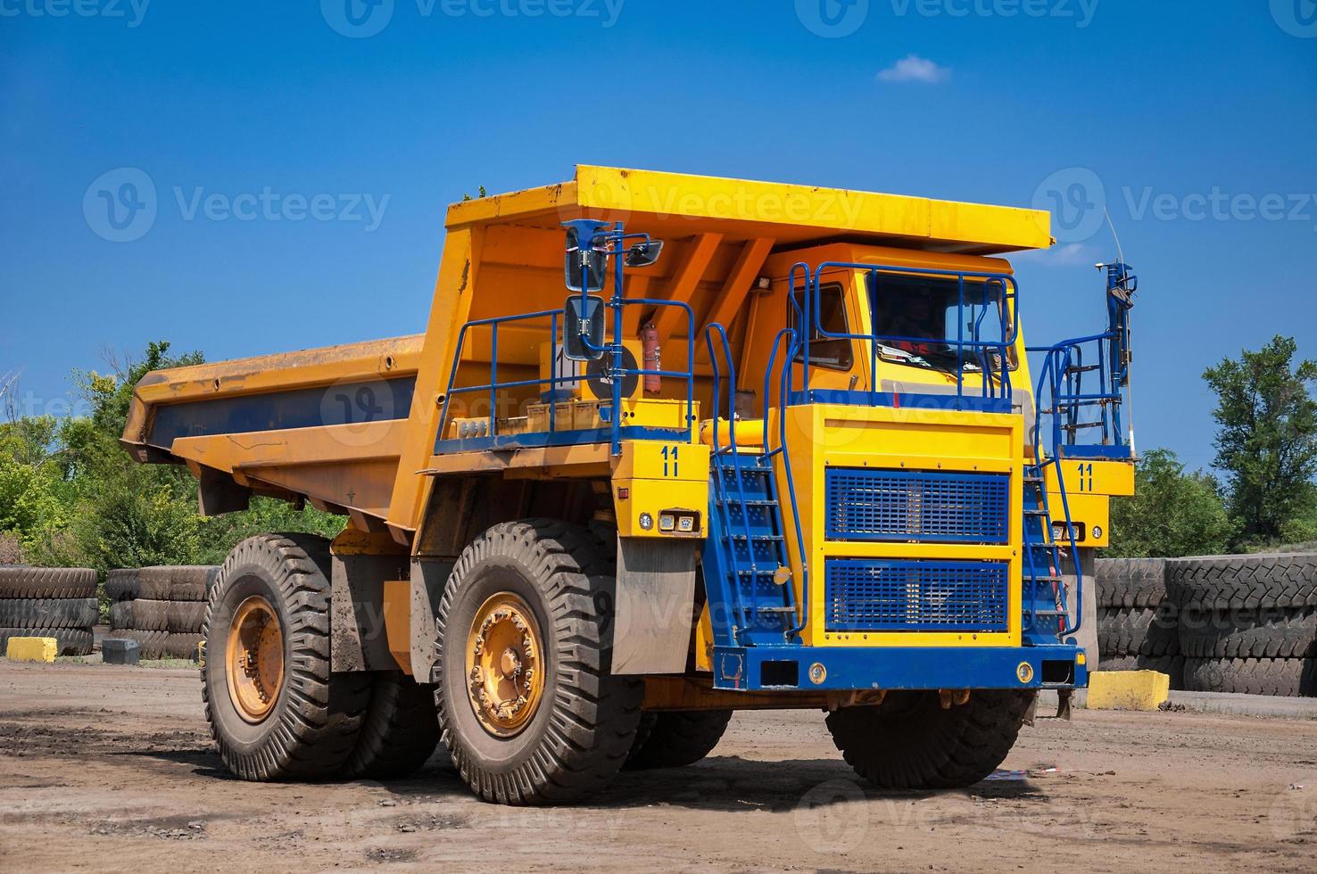 heavy yellow open cast mine dump trucks at repair station at sunny cloudless day photo