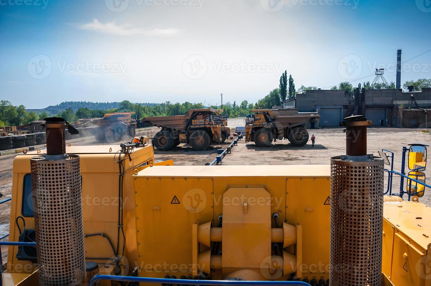 heavy yellow open cast mine dump trucks at repair station at sunny cloudless day photo