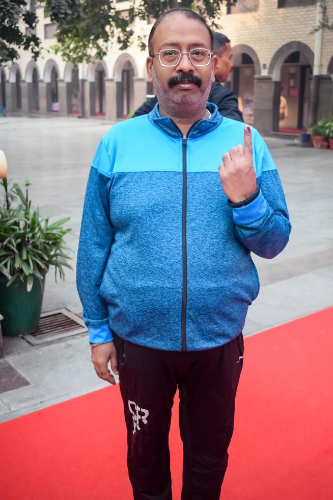 New Delhi, India - March 04 2023 - Unidentified people showing their ink-marked fingers after casting votes in front of polling booth of east Delhi area for MCD local body Elections 2022 photo