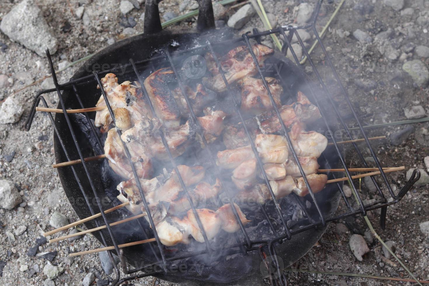 pollo satay siendo A la parrilla terminado carbones foto