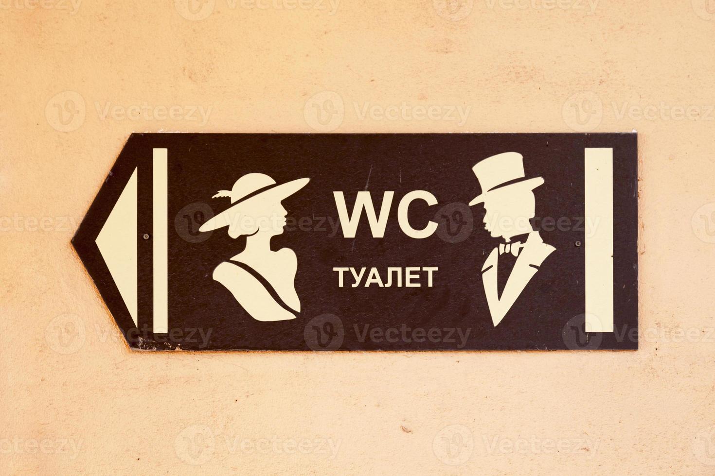 Toilet direction sign in English and Russian photo