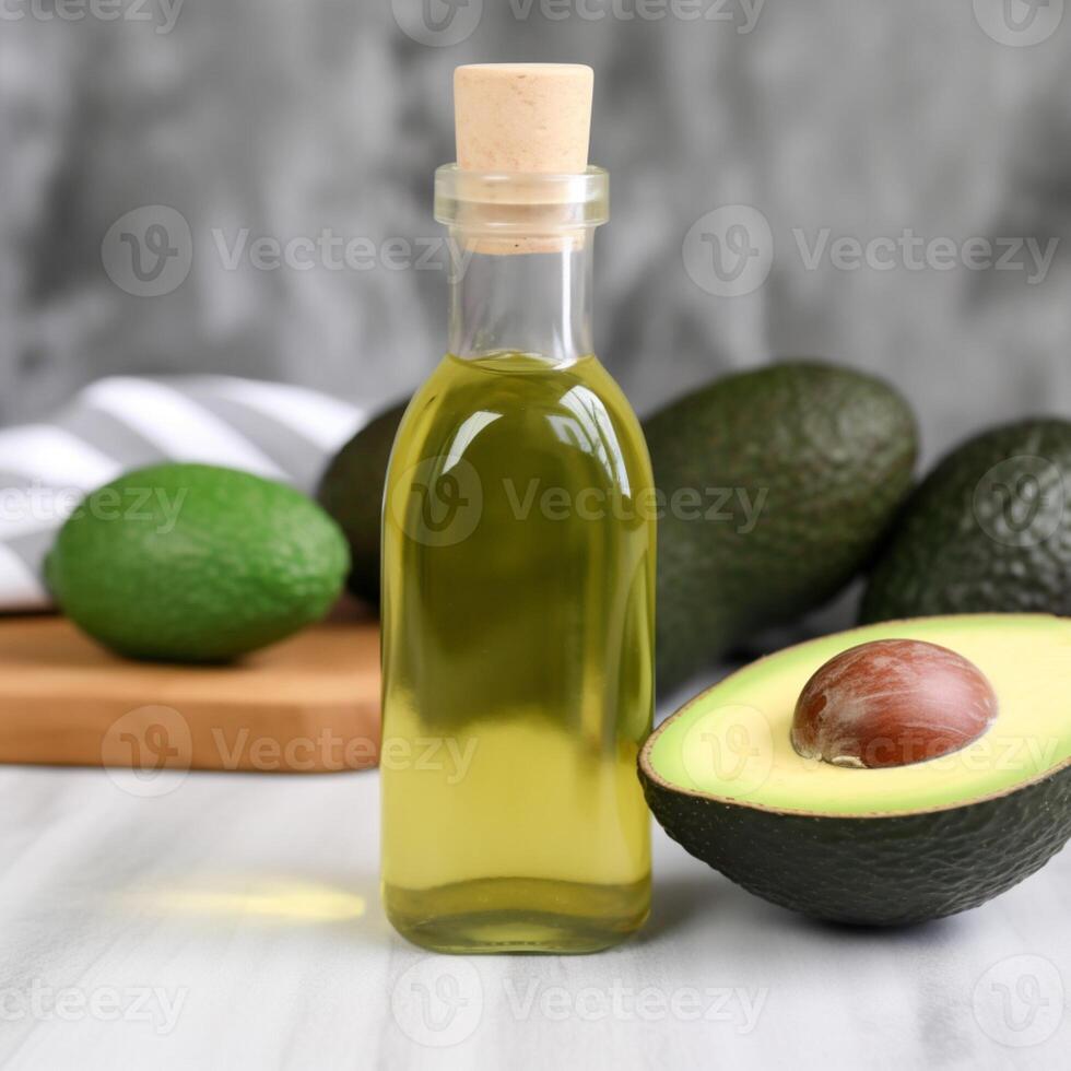 A bottle of olive oil with avocado on the table behind it photo