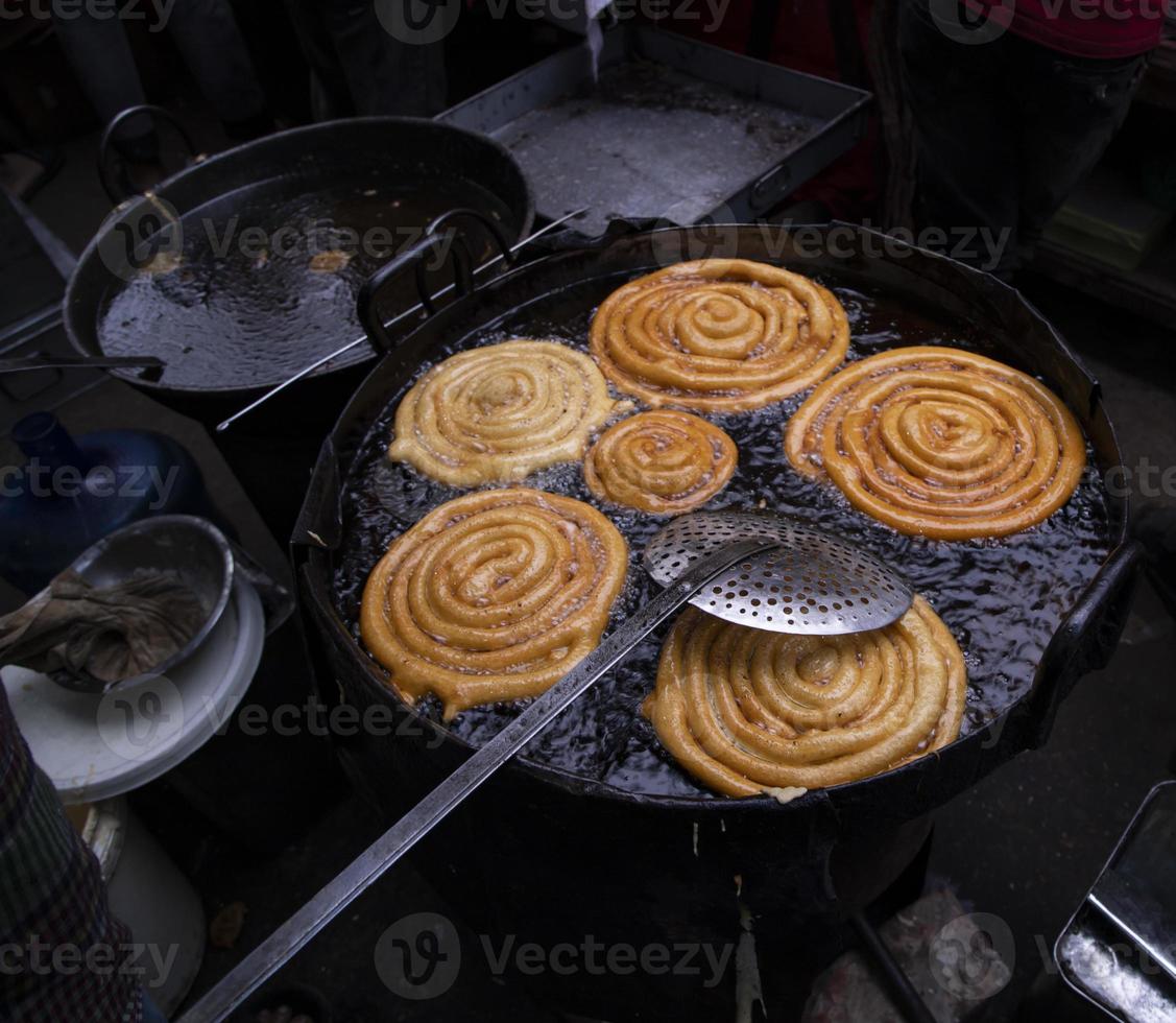 Delicious Testy sweet  jalebi fried in the cooking pan on a street food market in Chakbazar, Dhaka-Bangladesh photo