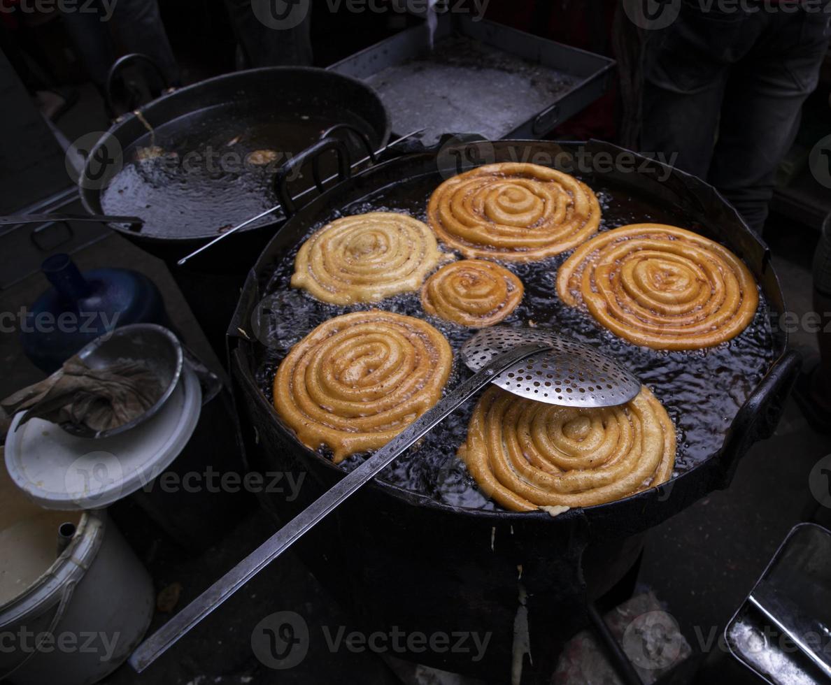 Delicious Testy sweet  jalebi fried in the cooking pan on a street food market in Chakbazar, Dhaka-Bangladesh photo