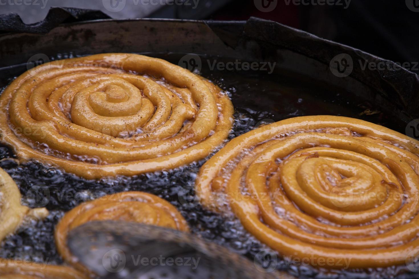 delicioso irascible dulce jalebi frito en el Cocinando pan en un calle comida mercado en chakbazar, dhaka-bangladesh foto