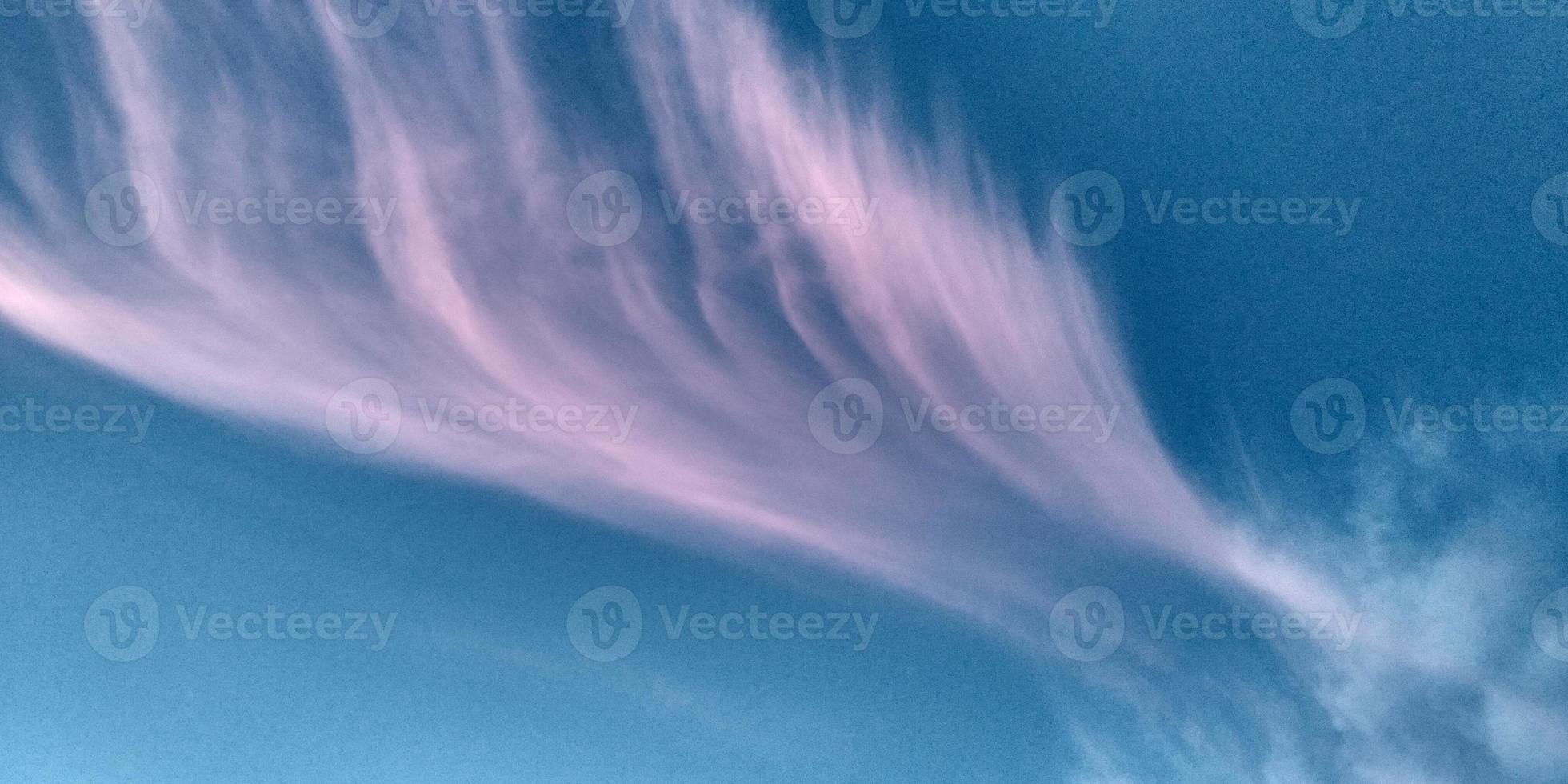 Blurred clouds background. Pink and white cloud like a wing on the blue sky. Sunset sky. photo