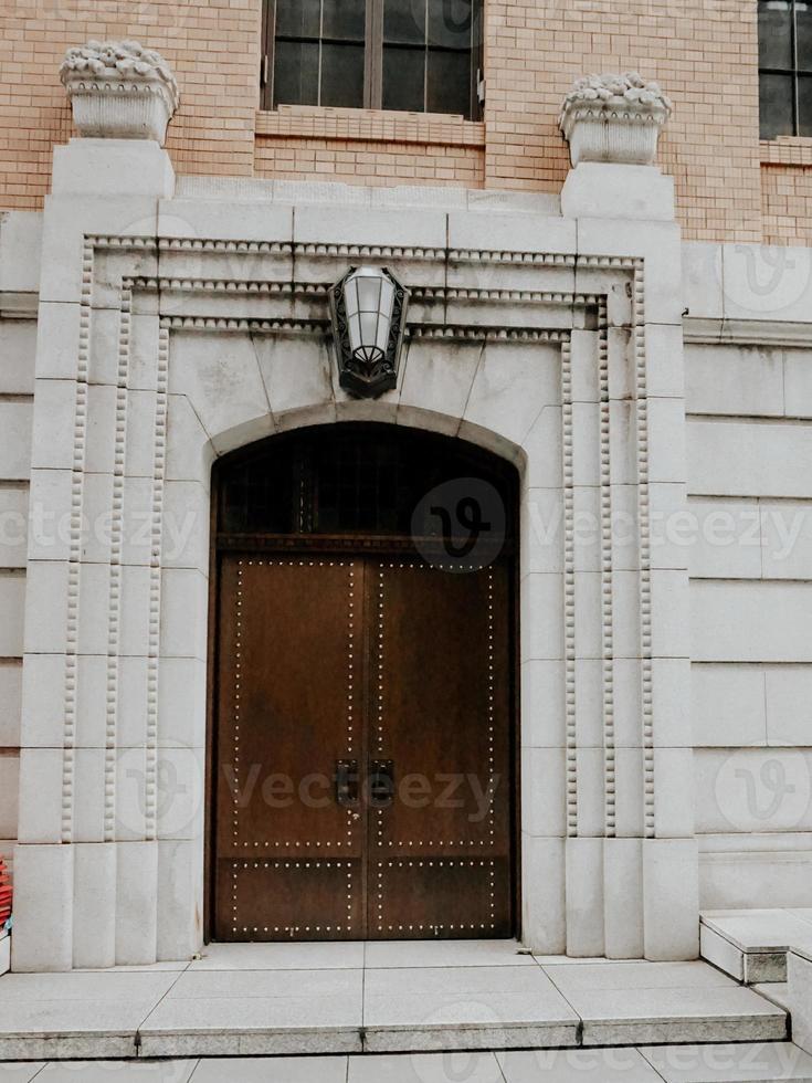 a vintage brown wooden door at a grey building photo