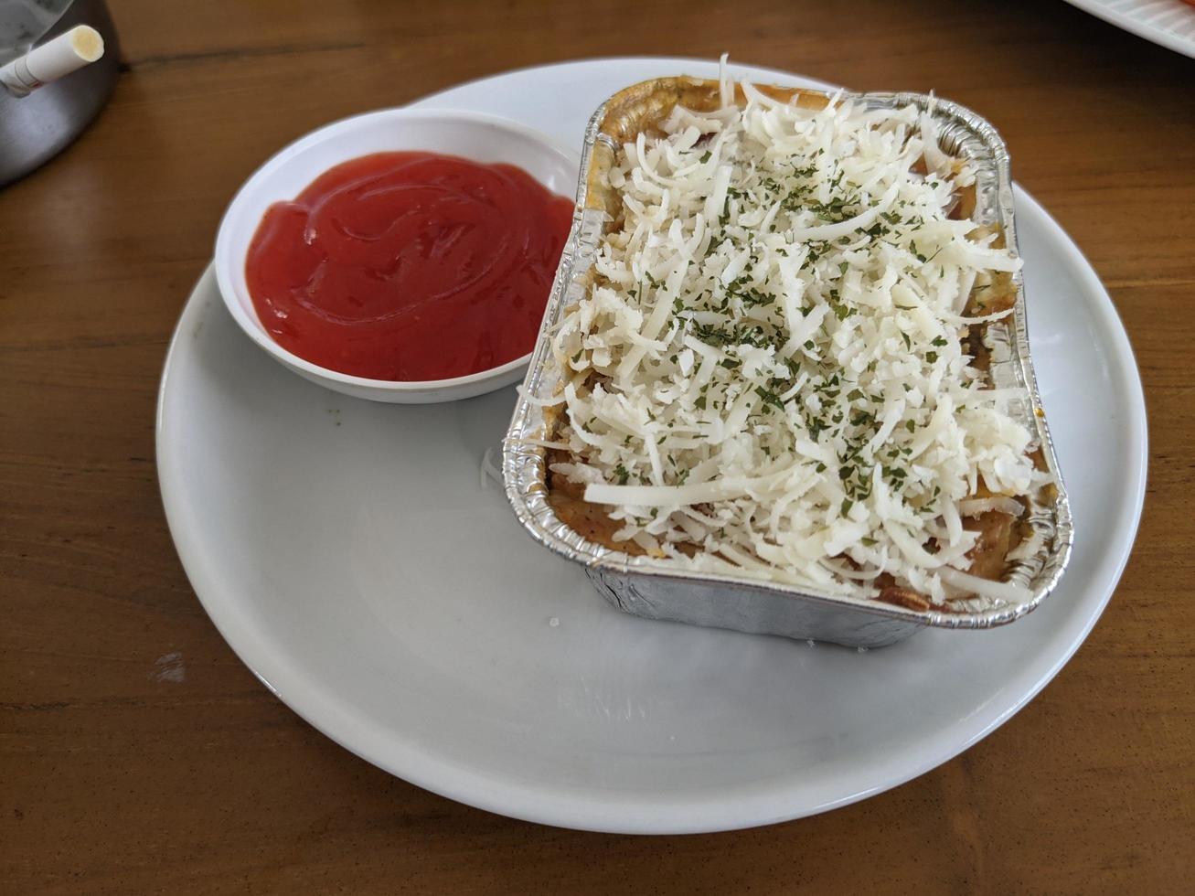 Cedar Cheese and mozzarella on the roasted beef lasagna with chili sauce. The photo is suitable to use for food background, poster and food content media.