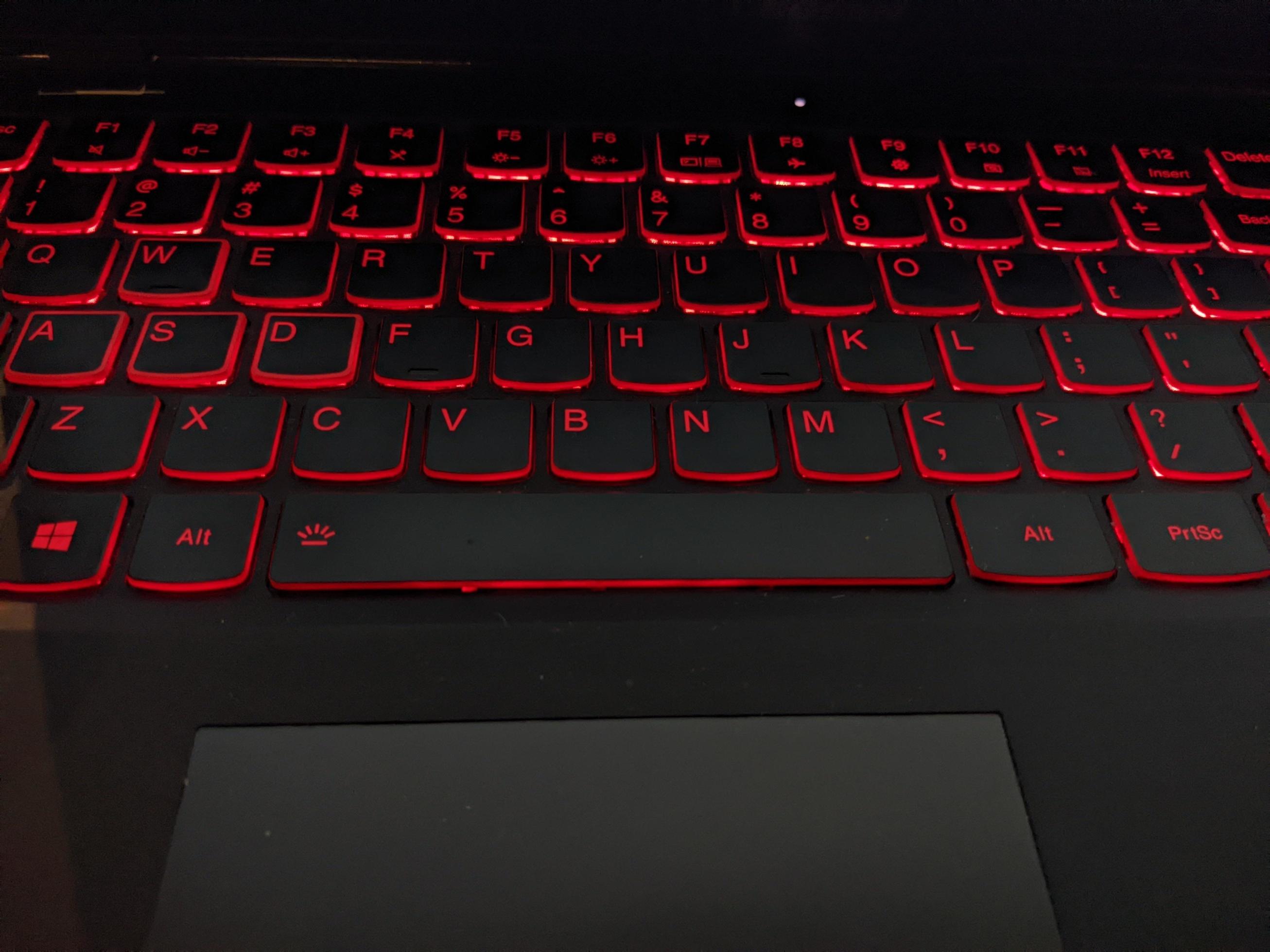 Keyboard with red backlight texting by hand. The photo is suitable