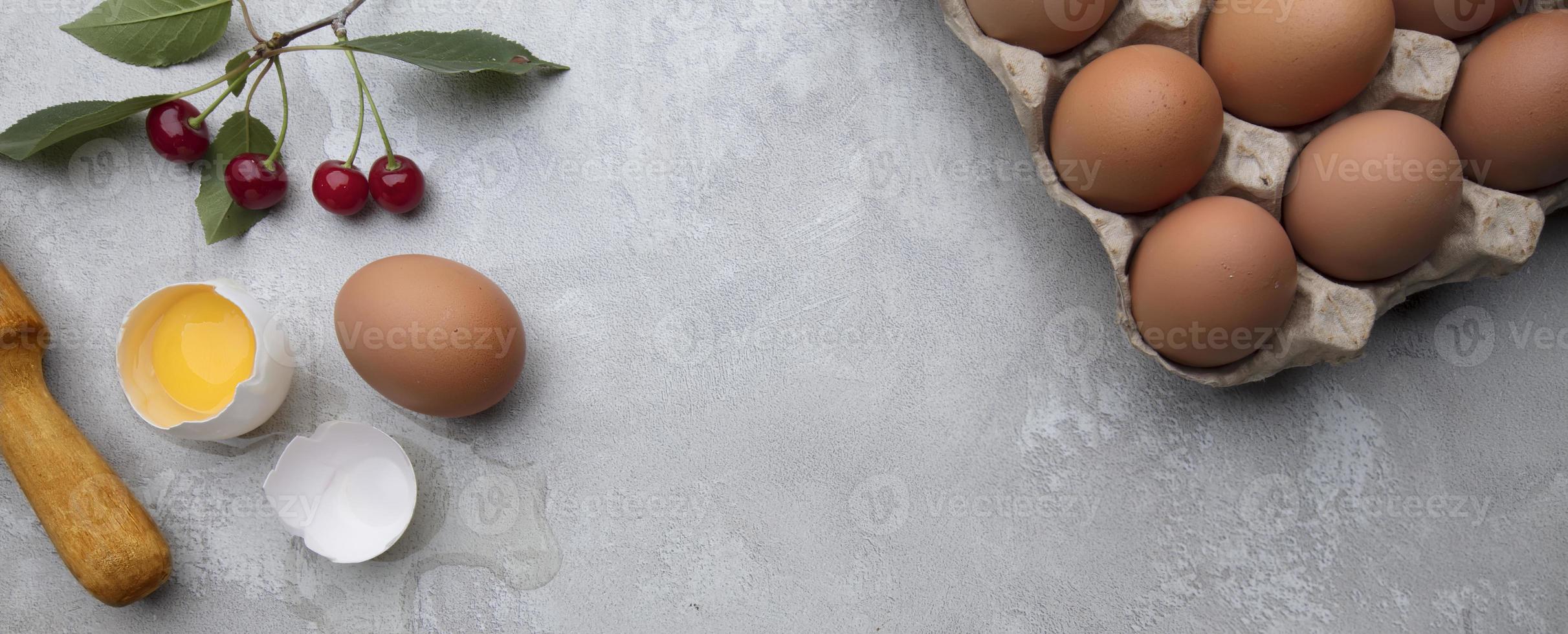 Ingredients for baking eggs rolling pin berries on a gray background. Cookie pie or cake recipe mockup. Preparing for culinary baking. photo