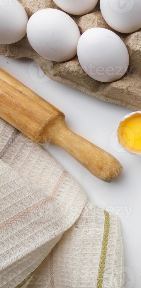 Baking cooking ingredients flour eggs rolling pin and kitchen textiles on a white background. Cookie pie or cake recipe mockup photo