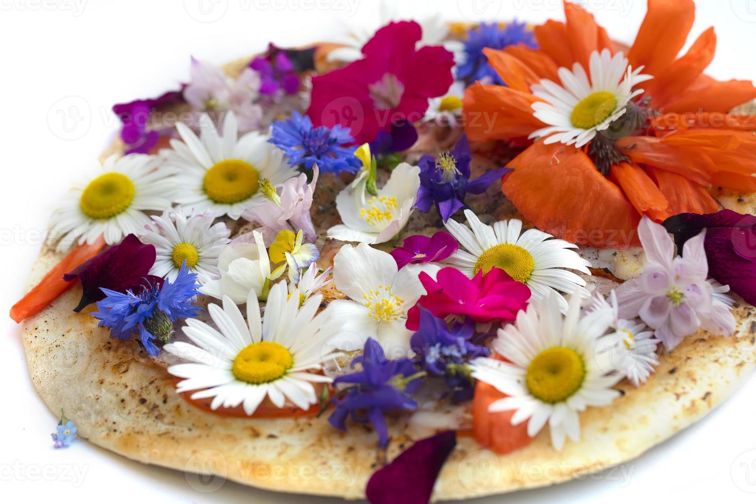 Creative pizza covered with colorful flowers. photo