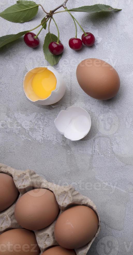 Ingredients for baking eggs rolling pin berries on a gray background. Cookie pie or cake recipe mockup. Preparing for culinary baking. photo