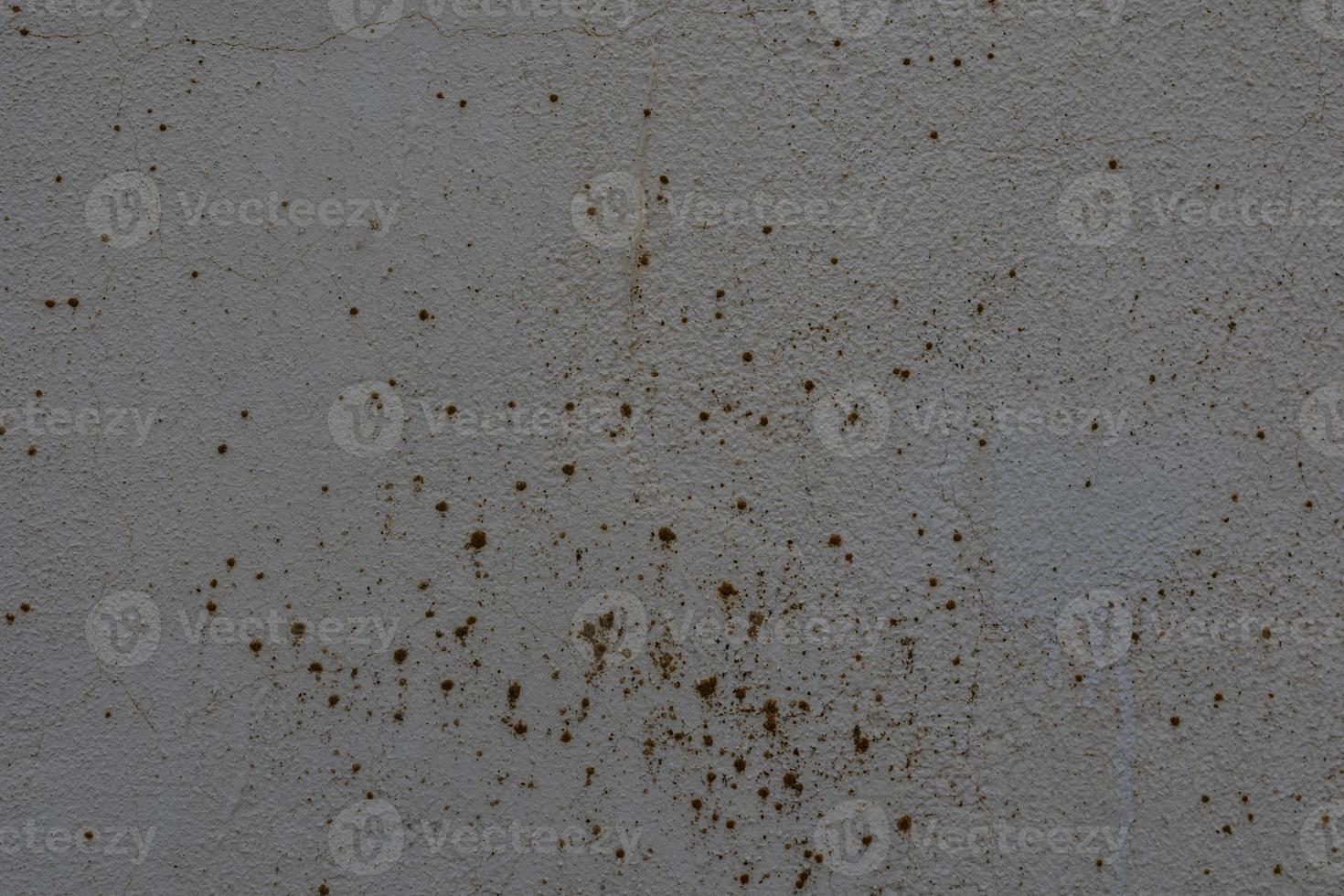 background of old gray wall with cracked plaster in close-up photo