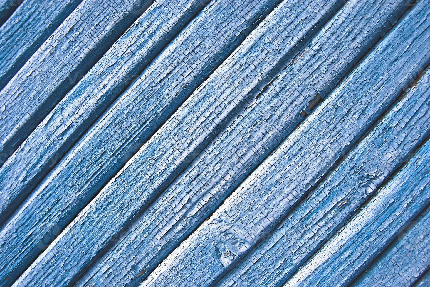 Wooden slats background with cracked blue paint, diagonally arranged photo