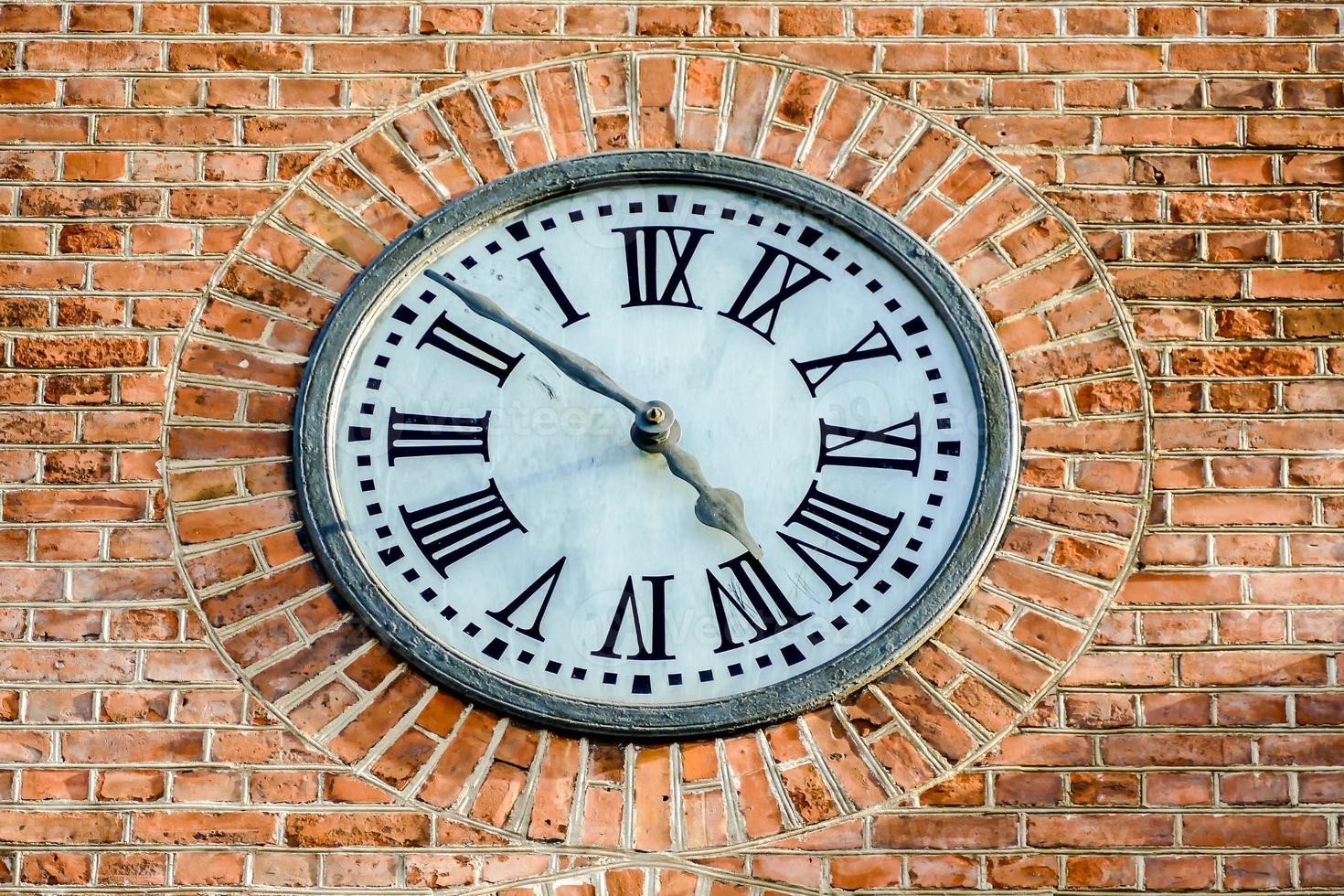 Clock on the brick wall photo