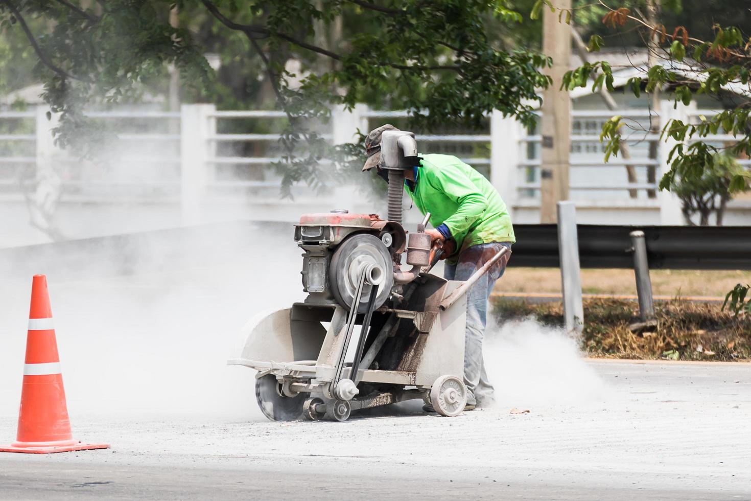 Worker cutting asphalt road photo