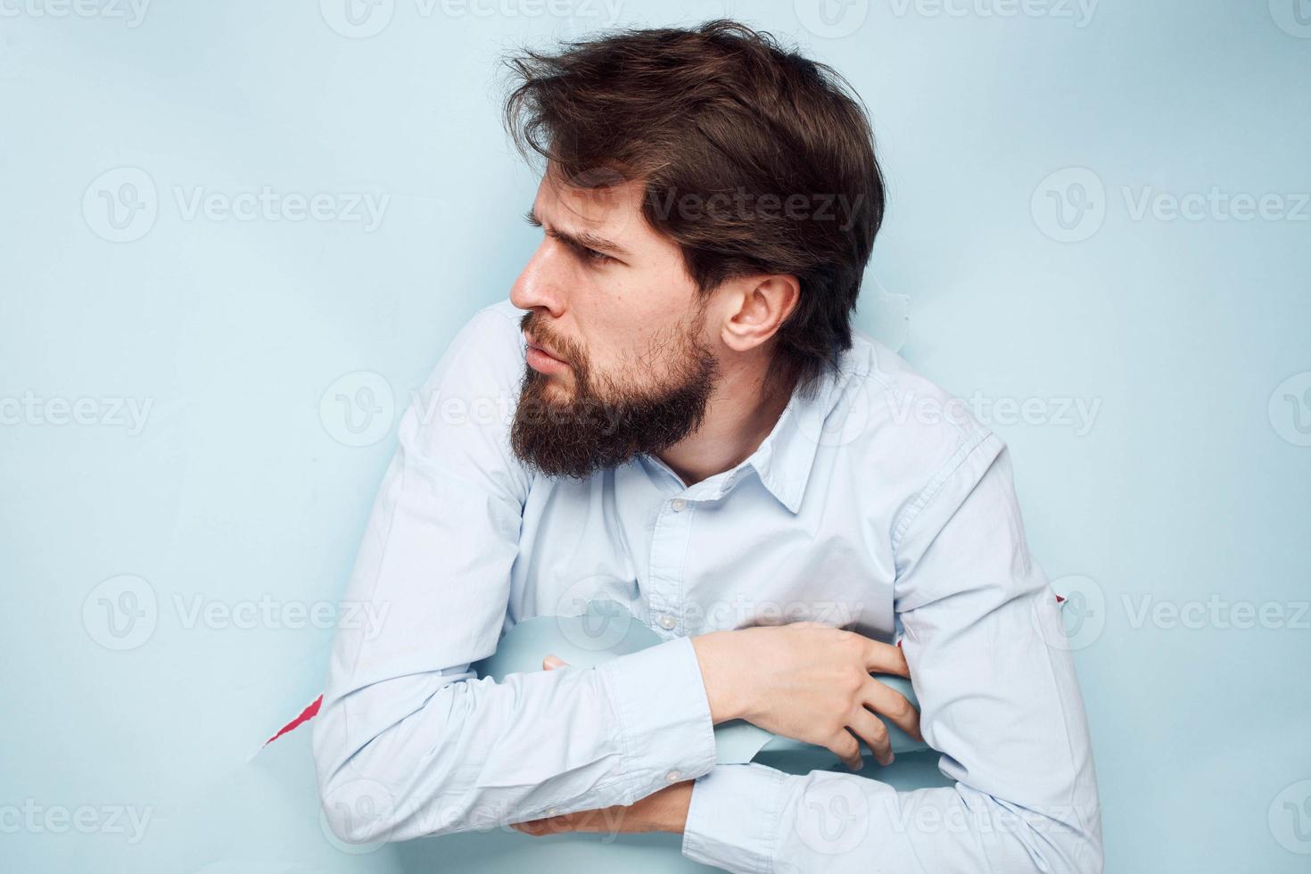 A business man in a shirt peeks out from behind a wall with emotions stress work photo