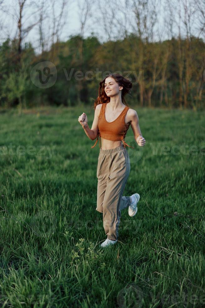 un atlético mujer carreras y trenes su cuerpo antes de el verano temporada en el parque foto