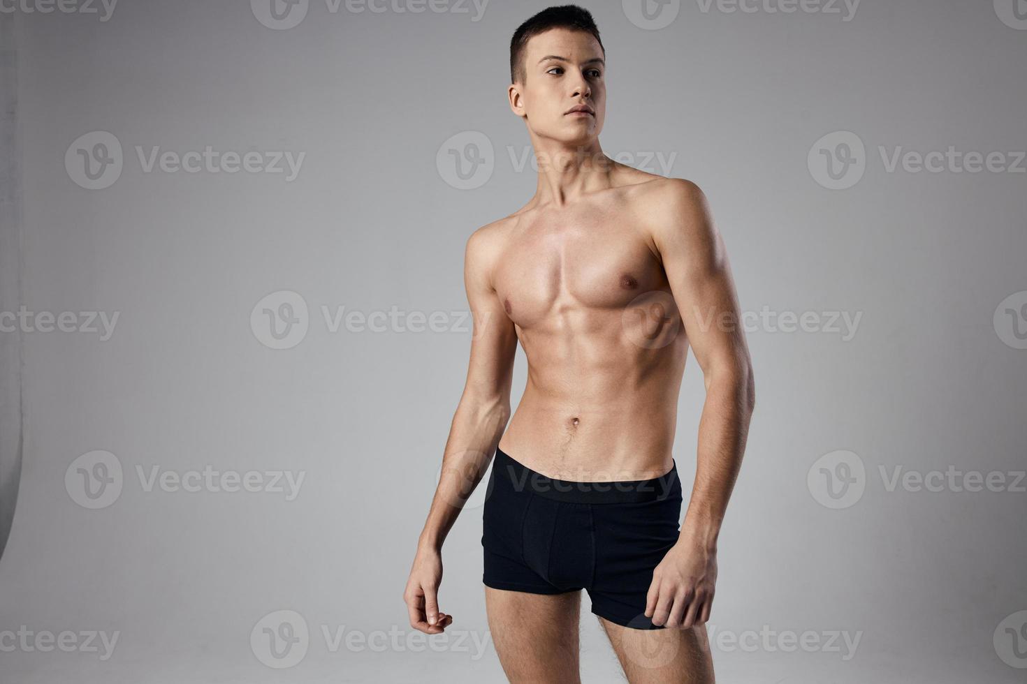 sexy bodybuilder in black shorts on gray background photo