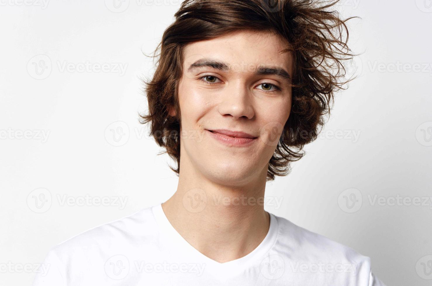 emocional chico en blanco camiseta despeinado pelo adolescente de cerca foto