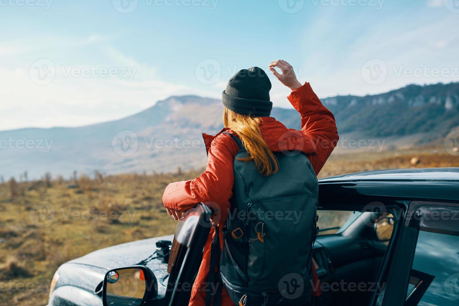 woman travels in nature with a backpack and near the car photo