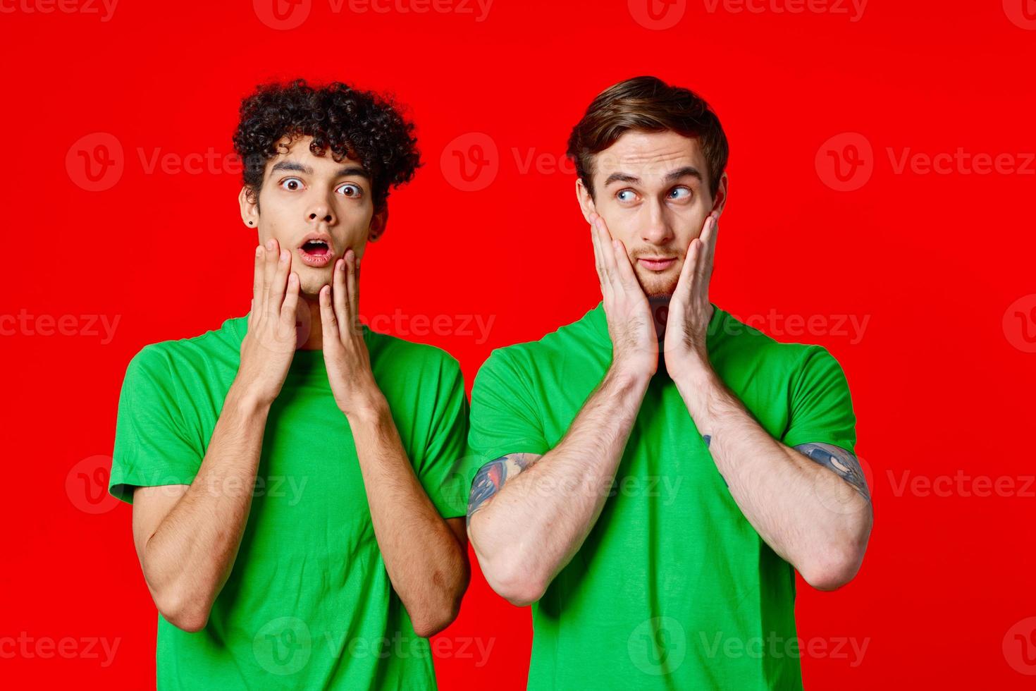 Cheerful friends in green t-shirts hold on to the face of emotion photo