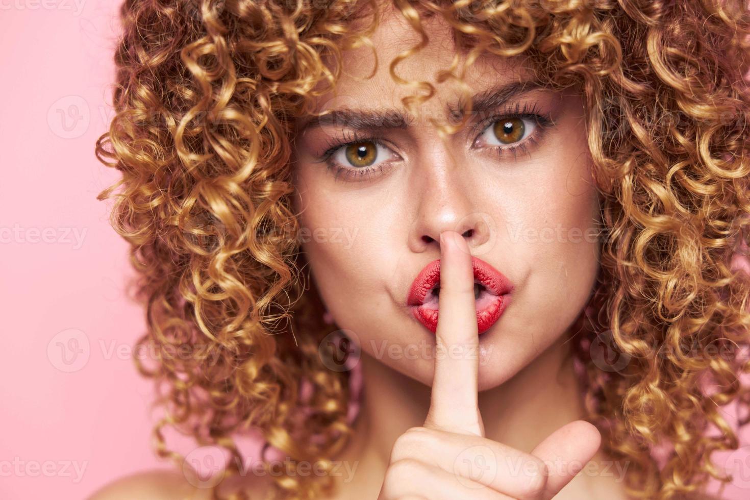 Female Holds his finger to his lips and looks forward portrait fashionable clothes photo