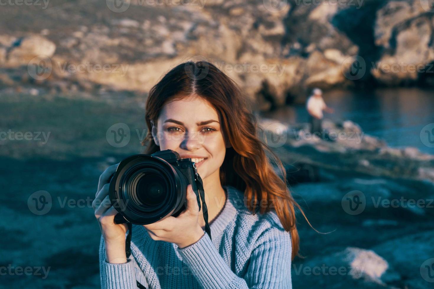 mujer con cámara en naturaleza tomando imágenes de paisaje profesional foto