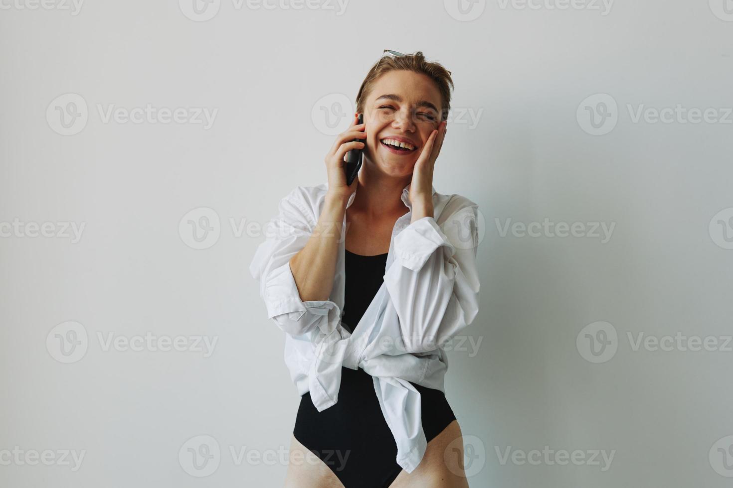 Adolescente niña sonriente y riendo hablando en el teléfono, vídeo llamar, chateando en línea foto