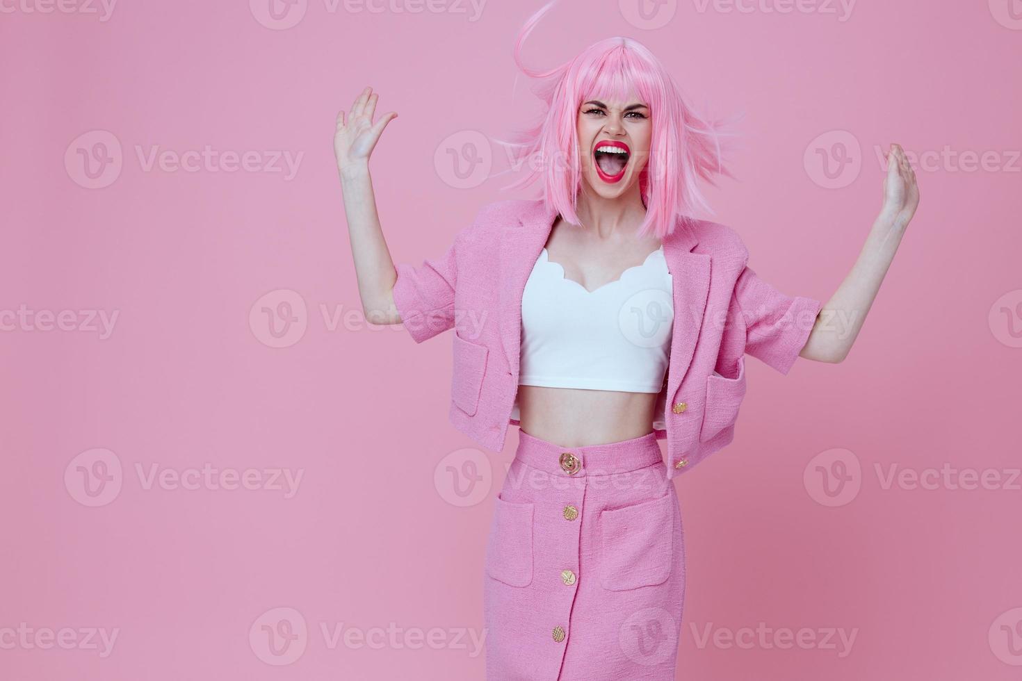 Young positive woman in a pink suit gesturing with his hands emotions fun color background unaltered photo
