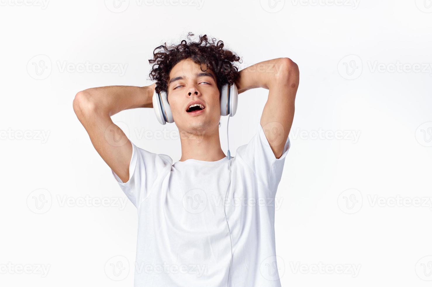 curly guy in headphones listens to music emotions entertainment photo