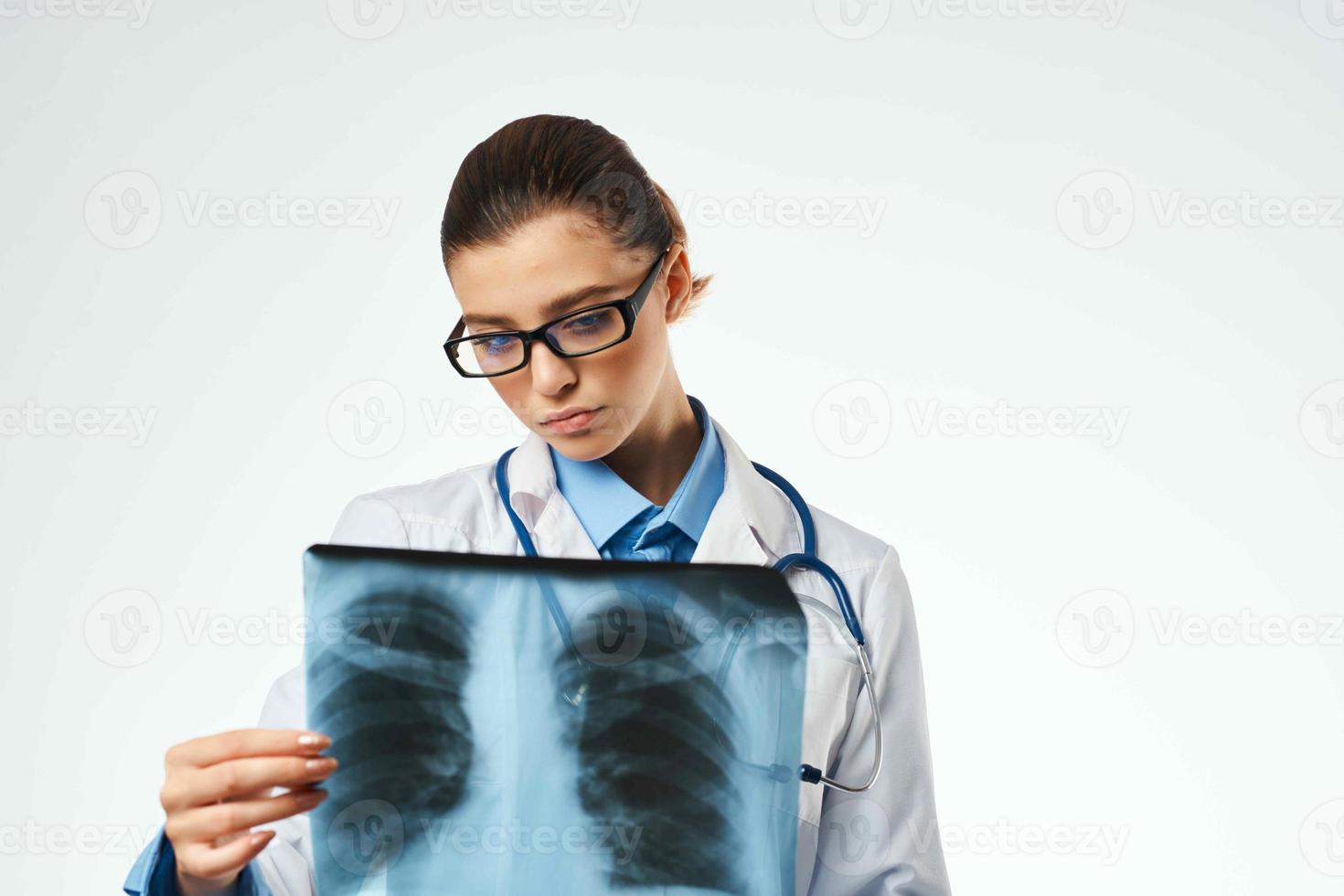 un enfermero en un blanco Saco mirando a un radiografía profesional examen foto