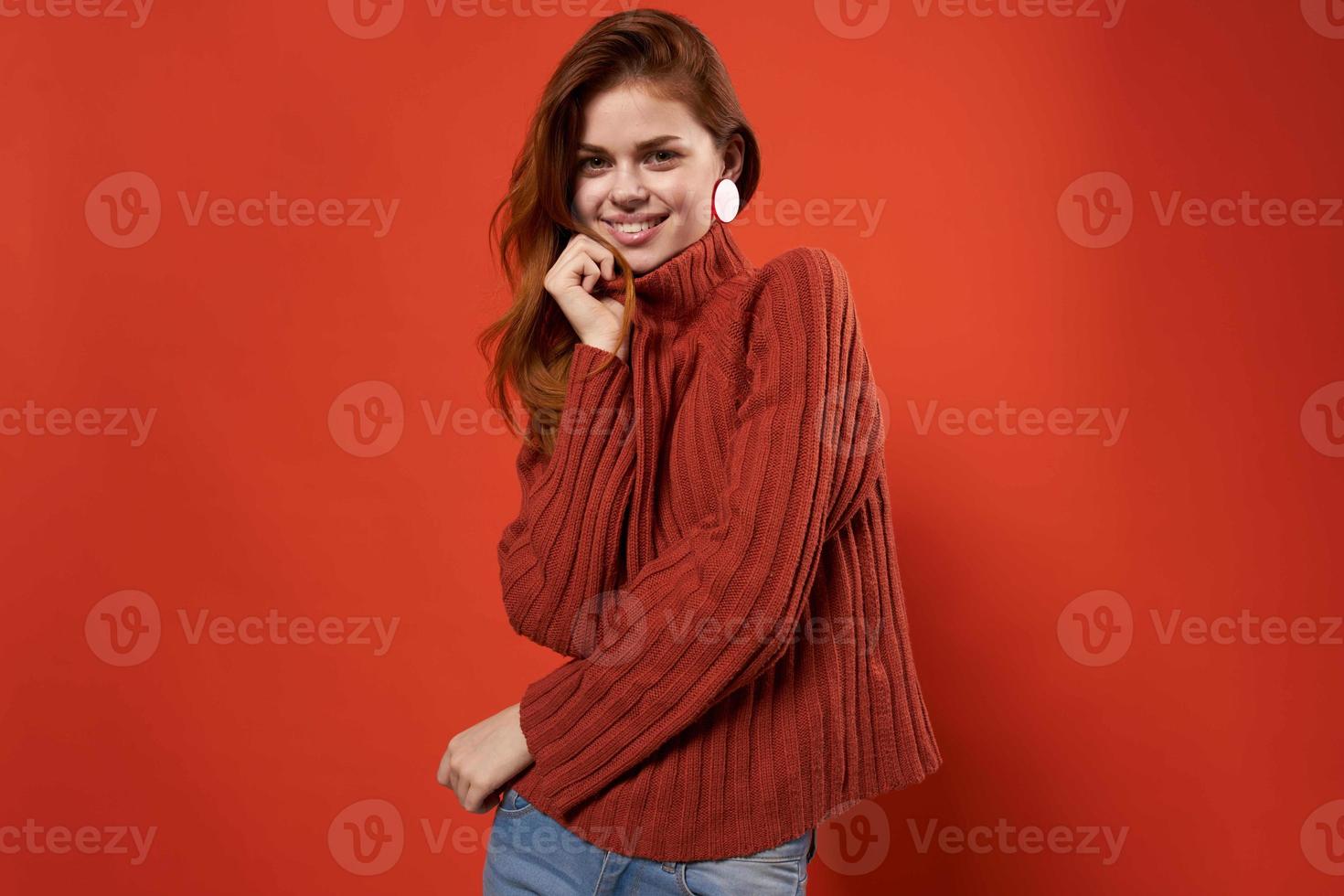 cheerful woman in a red sweater makeup earrings fashion studio photo