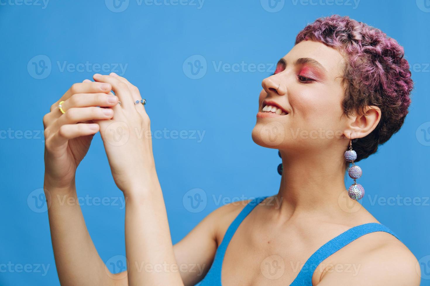 joven atlético Moda mujer posando en azul ropa de deporte sonriente y mirando a el cámara en un azul monocromo antecedentes foto