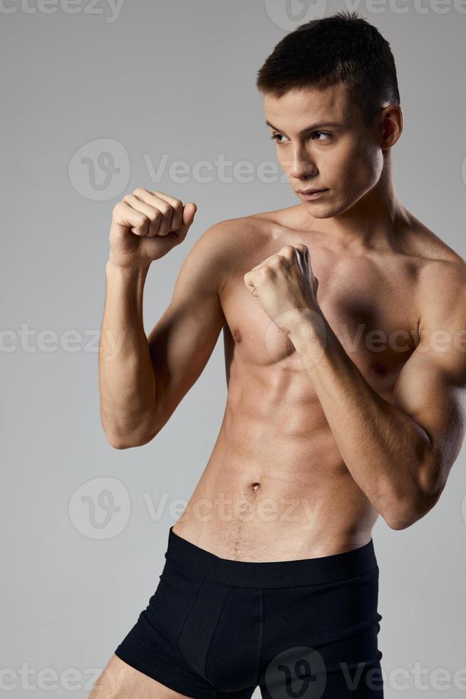 sexy boxer in shorts naked torso hands in fist model photo