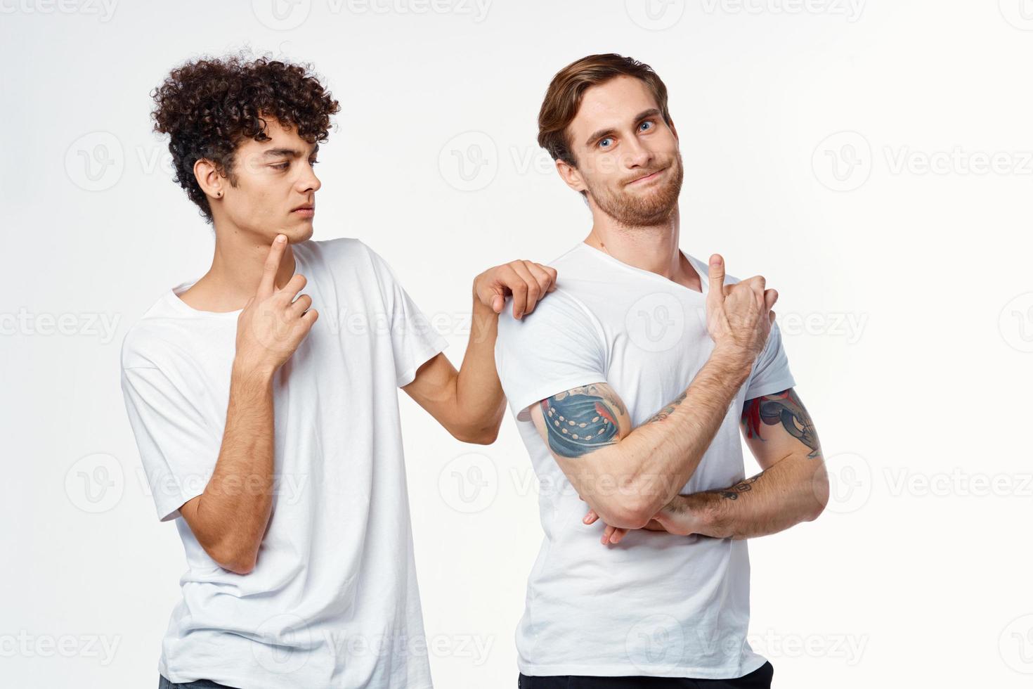 two men in white t-shirts are standing side by side isolated background photo