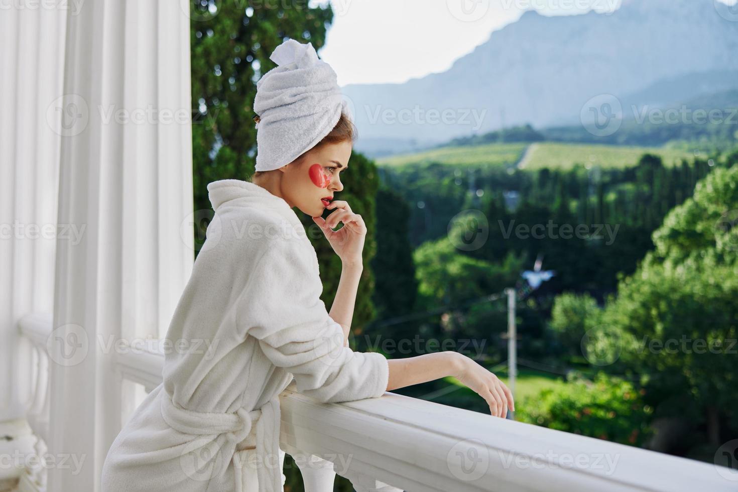 Woman in a bathrobe stands on the balcony of the hotel unaltered photo