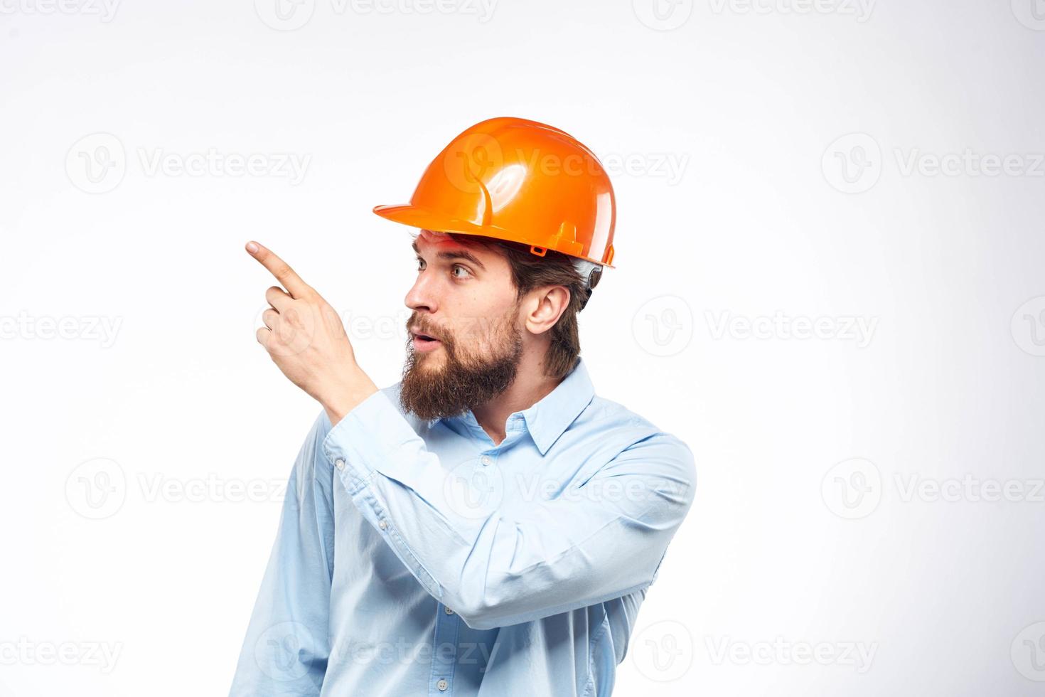 Man in orange hard hat industry engineer work professional light background photo
