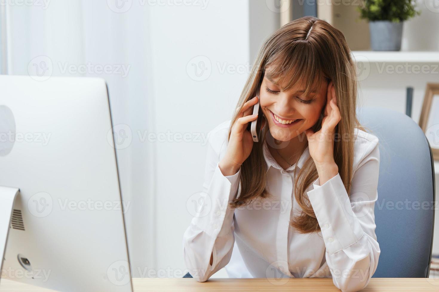 Smiling happy adorable blonde businesswoman worker freelancer talking with client in call in light modern office. Enjoyed employee work on computer online in support service. Copy space photo