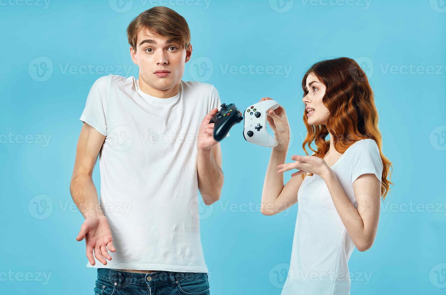 young couple t-shirt with joysticks in hands video games technology blue background photo