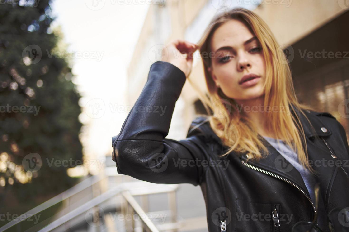 Portrait of woman in leather jacket near street model shopping building photo