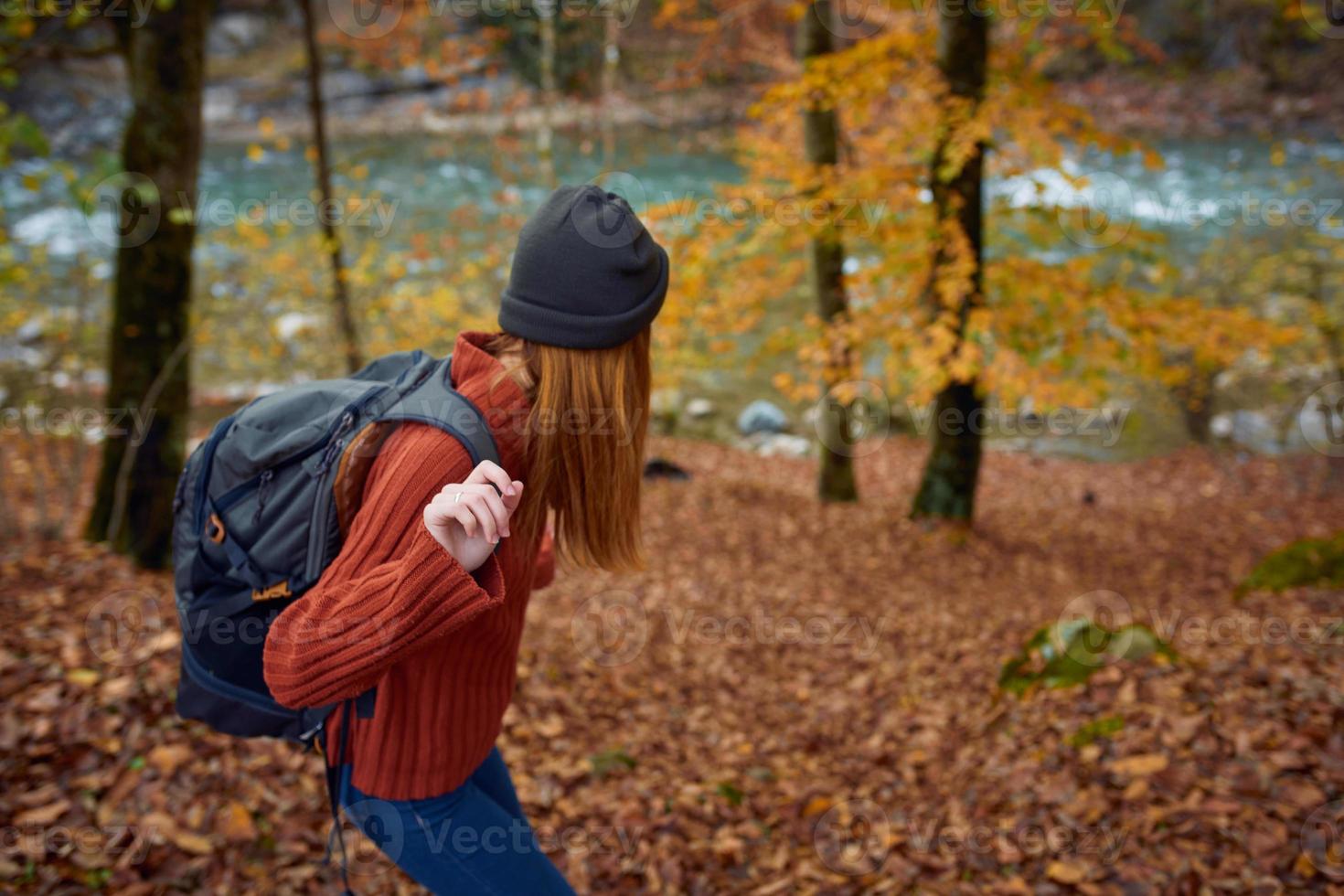 woman with backpack travel in autumn forest photo