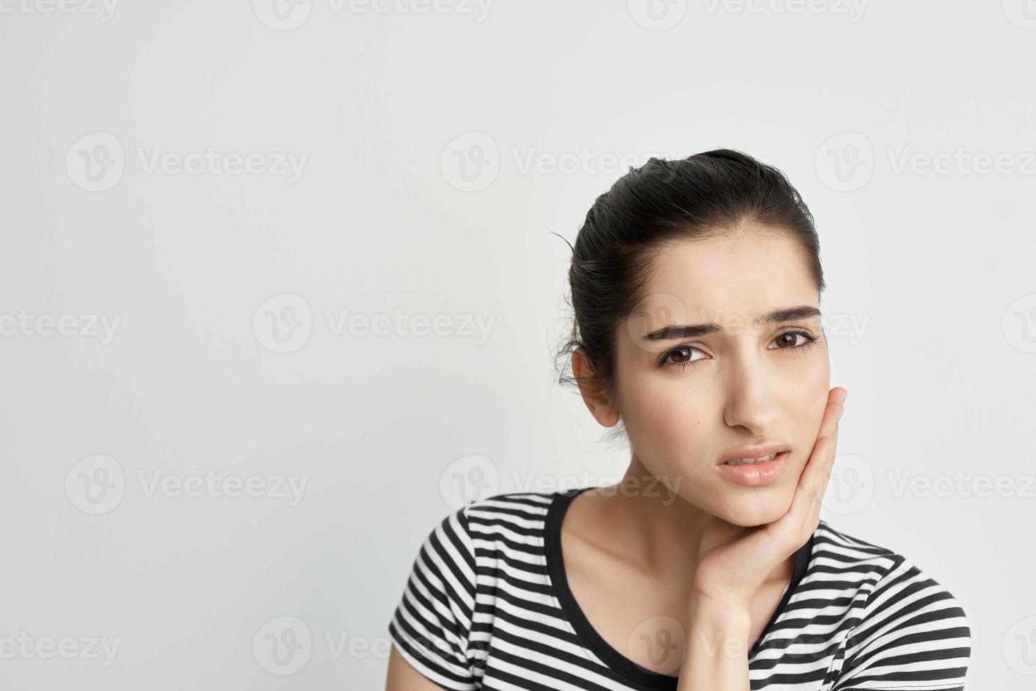 woman holding on to face toothache health care light background photo