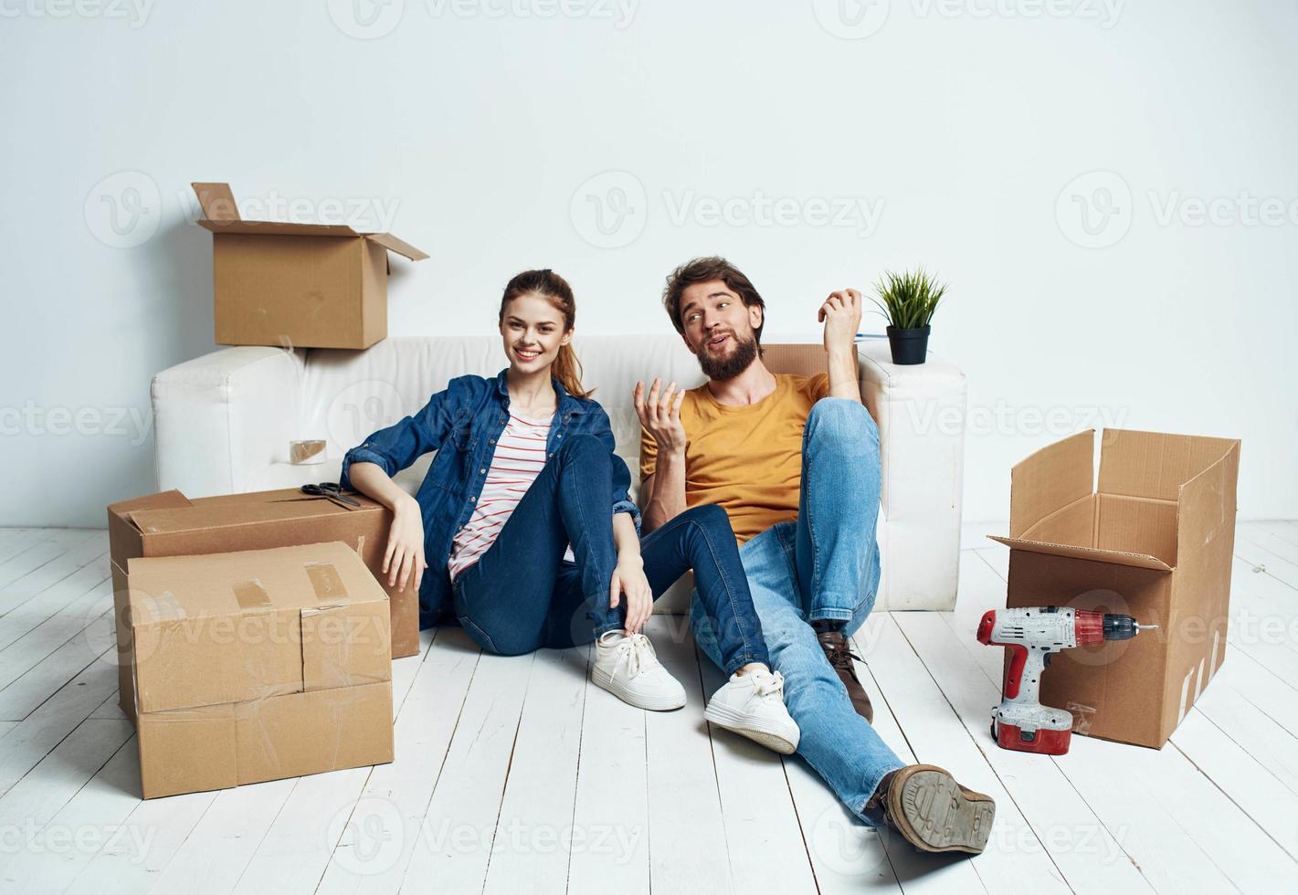 Moviente renovación contento hombre y mujer en el piso en un nuevo Departamento con cajas foto