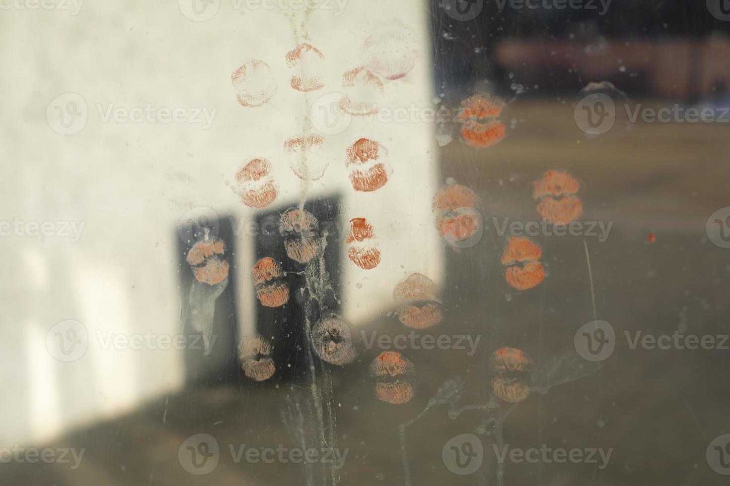 Lipstick marks on mirror. Lots of kisses on glass. photo