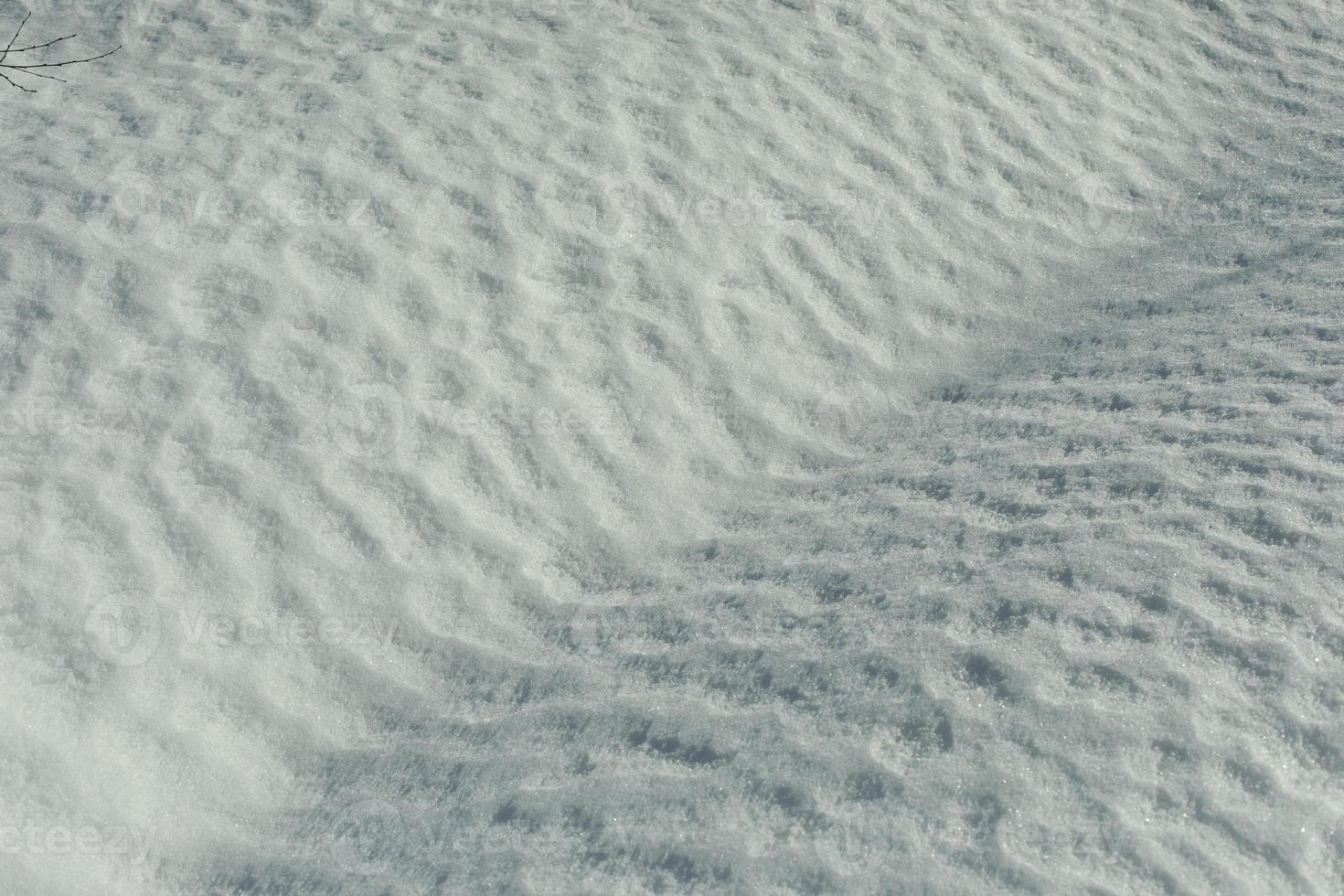 Texture of snow. Snow melts in spring. Waves on surface. Natural background is winter. photo