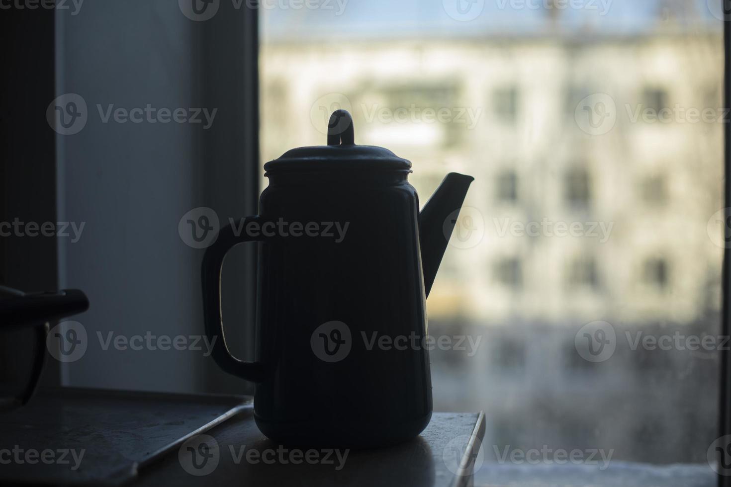 Kettle in kitchen. Water kettle. Darkens indoors. photo